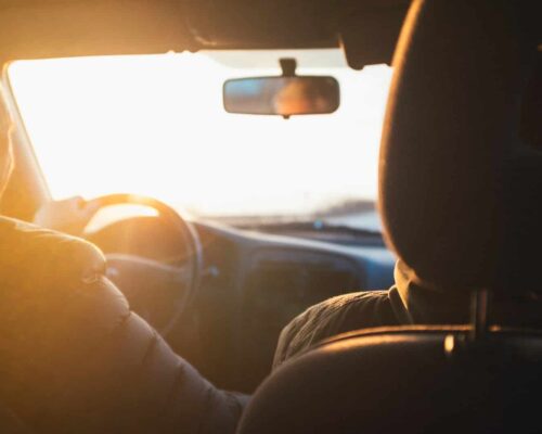 man driving car during golden hour